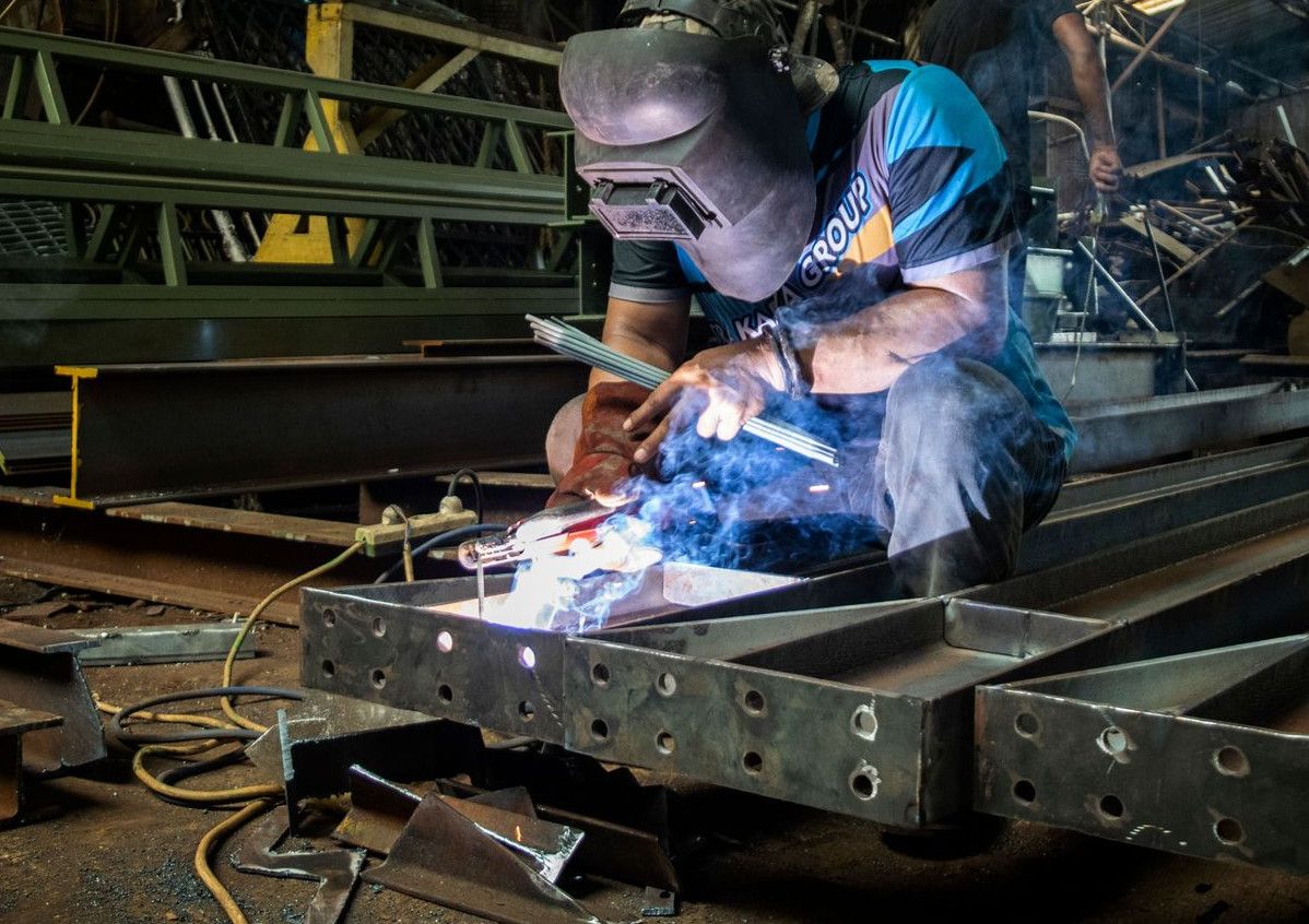 A professional welder demonstrates precision and skill in a metal workshop in Jakarta, Indonesia.